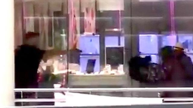 El 'mosso', aún con la bata de la peluquería encima, encañona a los atracadores del Ànec Blau