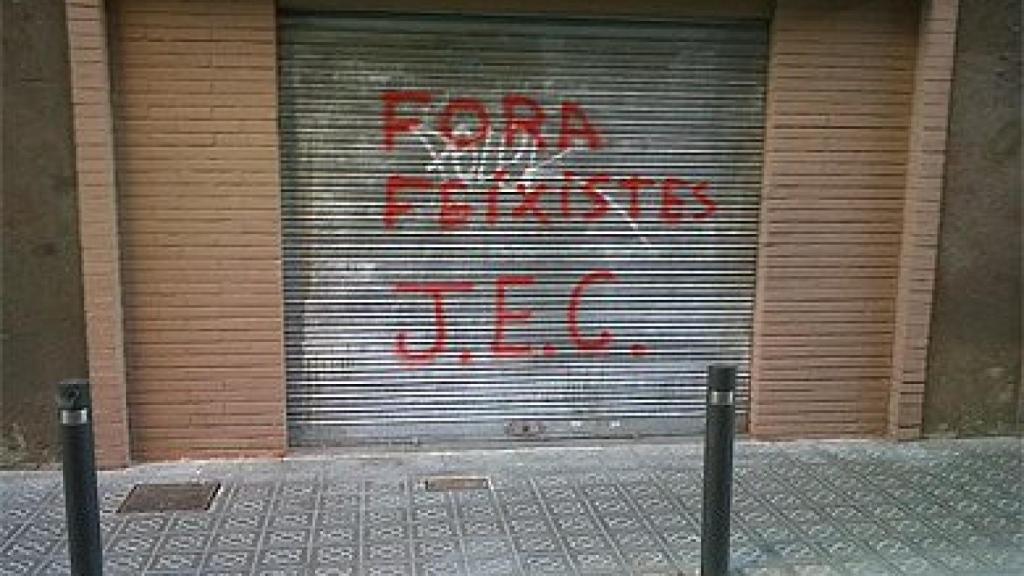 Sede del PP del barrio de Les Corts con una pintada insultante en la persiana
