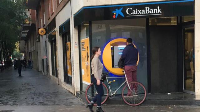 Un hombre retira efectivo en un cajero de Caixabank situado en la calle Marina de Barcelona / CG