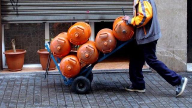 Un hombre carga seis bombonas de butano, en una imagen de archivo / EFE