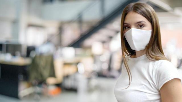 Una chica se protege con una mascarilla reutilizable R40 en su puesto de trabajo / REPROTECT