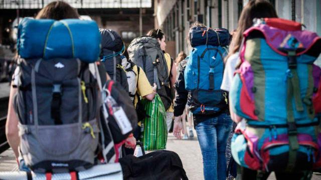 Jóvenes con mochila antes de subir a un tren / EFE
