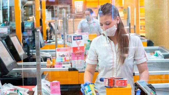 Una dependienta protegida contra el coronavirus en su puesto de trabajo / EFE