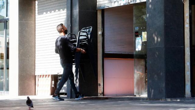 Un camarero, recogiendo mesas en un bar de la Barceloneta, en Barcelona / EFE