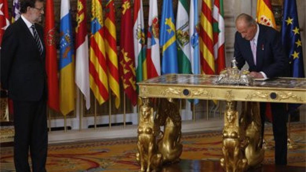 Juan Carlos I firma su abdicación en presencia del presidente del Gobierno, Mariano Rajoy