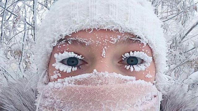 Una joven con las pestañas y la cara congelada en Siberia