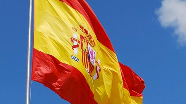 La bandera española constitucional ondea sobre un cielo azul intenso / CG