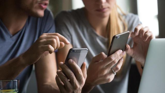 Dos personas utilizan su teléfono móvil / EP