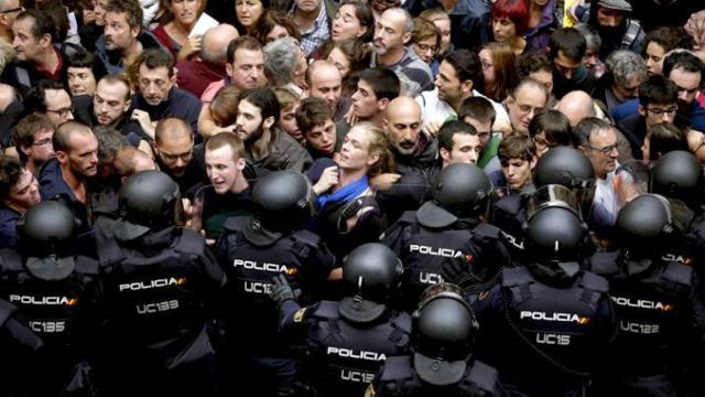 Policía y activistas del independentismo durante la jornada del referéndum ilegalizado del 1-O / EFE