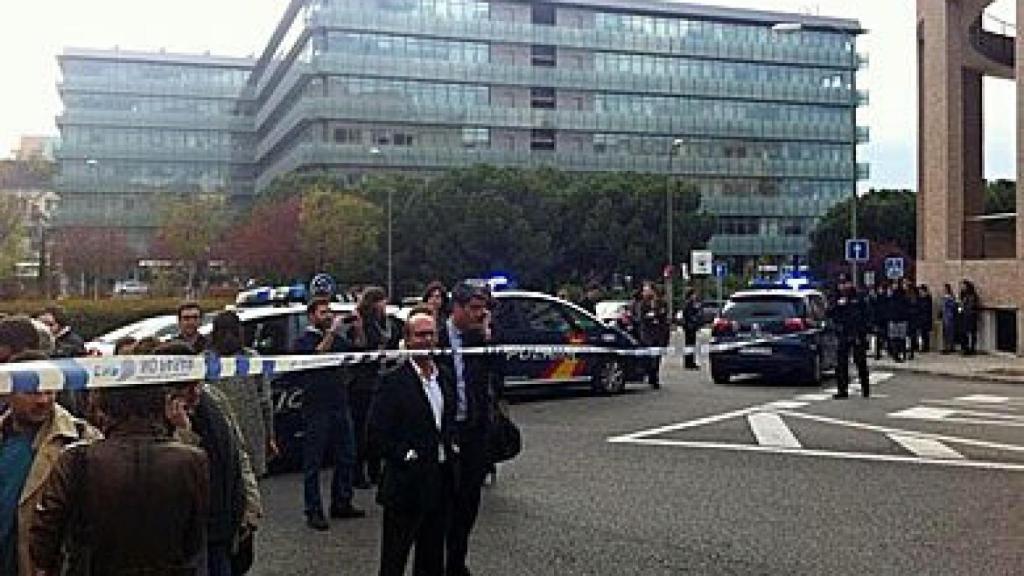 Empleados de 'Abc' esperan a las puertas de la sede, tras el cordón policial, mientras los agentes comprueban la veracidad de la amenaza de bomba