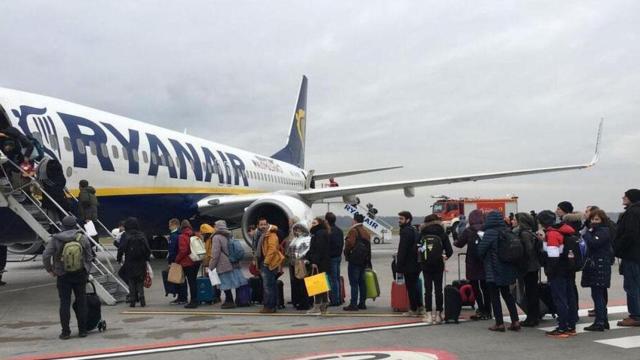 Sector turístico. Un avión de Ryanair con una cola de pasajeros  / EE