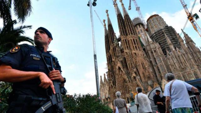 La Sagrada Familia de Barcelona, custodiada por un agente de los Mossos d'Esquadra / EFE