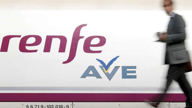 Un pasajero camina por delante de un tren AVE de Renfe / EFE