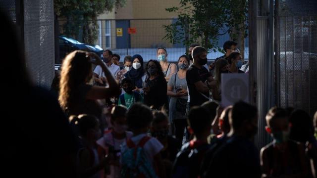 Padres y alumnos esperan a las puertas de un colegio en Cataluña, donde el nuevo curso escolar arranca este lunes / David Zorrakino (EP)