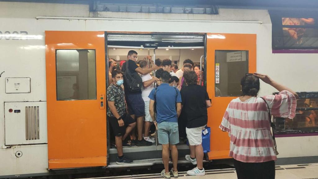 Tren de Rodalies de la R2 con el aforo completo en una de las estaciones, mientras tres personas miran cómo acceder / CG