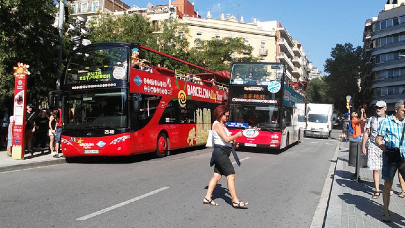Una mujer cruza la carretera sin mirar en la plaza de la Sagrada Familia./ CG