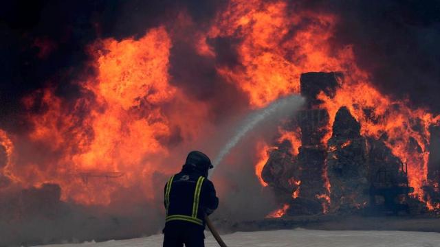 Los bomberos actuán contra el incendio en una nave de residuos de Asturias / ELOY ALONSO - EFE