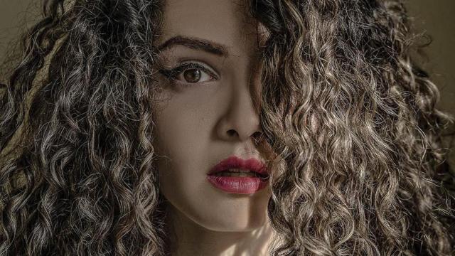 Mujer con el pelo rizado / UNSPLASH