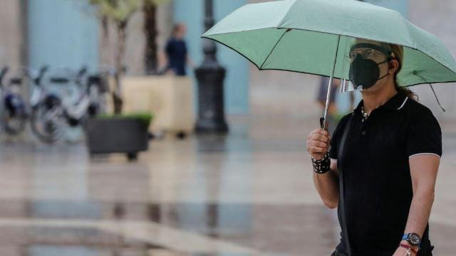 Una persona sostiene un paraguas por lluvias. Tiempo / Rober Solsona (EP)