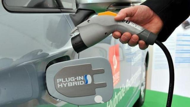 Un hombre conecta un cargador a un coche eléctrico en una estación de recarga /EFE