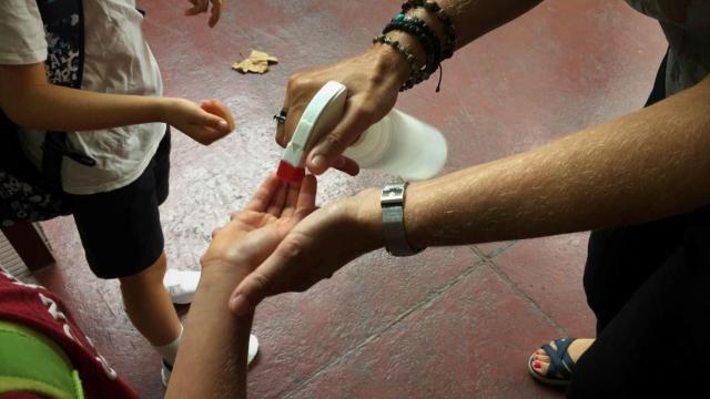 Una maestra dispensa gel hidroalcohólico a sus alumnos para protegerlos del coronavirus / EP
