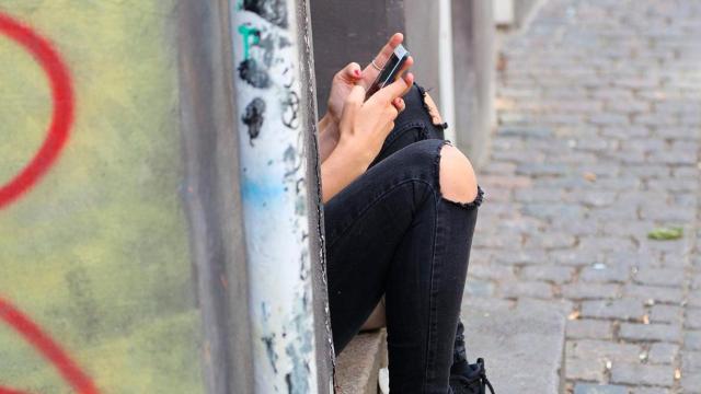 Una chica manda mensajes desde su móvil escondida / FREEPIK