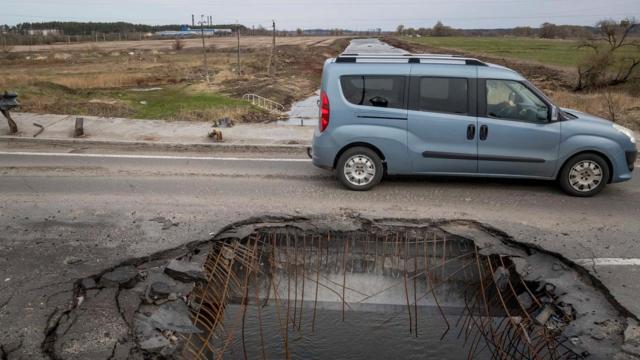 Un coche pasa por un puente destrozado por proyectiles en Bucha, cerca de la capital ucraniana, Kiev / MIGUEL GUTIÉRREZ - EFE