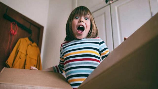 Niña sorprendida al abrir un paquete