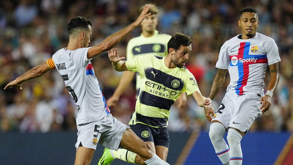 Bernardo Silva, intentant superar Busquets i Raphinha, durant l'amistós entre el Barça i el Manchester City / EFE