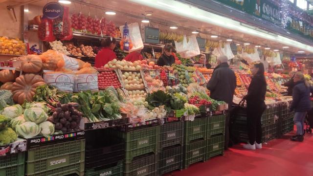 Varios personas comprando en el 'Mercat de Sant Ildefons' de Cornellà para las comidas y cenas de Navidad, que sufren las alzas del IPC / CG