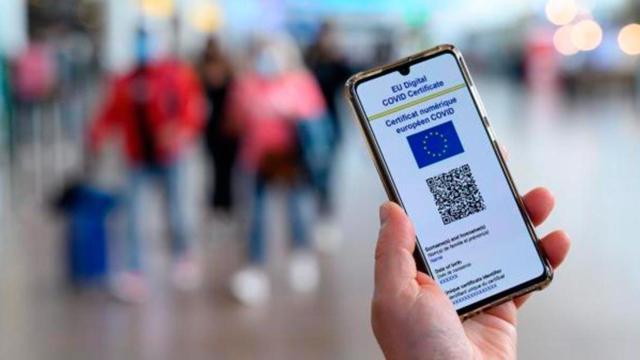 Un pasajero sostiene su teléfono móvil con el Certificado Covid en el aeropuerto / COMISIÓN EUROPEA