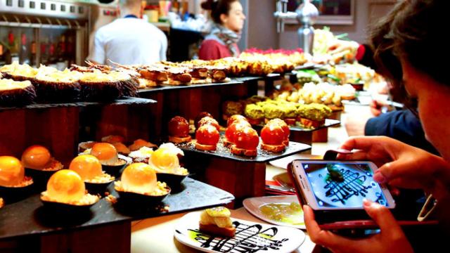 Una turista fotografía con su teléfono móvil un pintxo en un bar de la Parte Vieja de San Sebastián / EFE