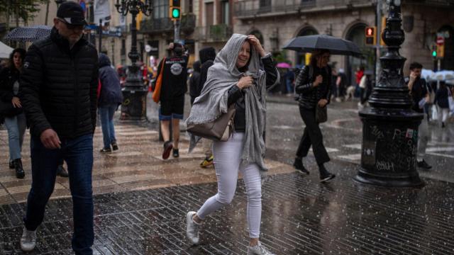 Varias personas se cubren de la lluvia / LORENA SOPENA - EUROPA PRESS