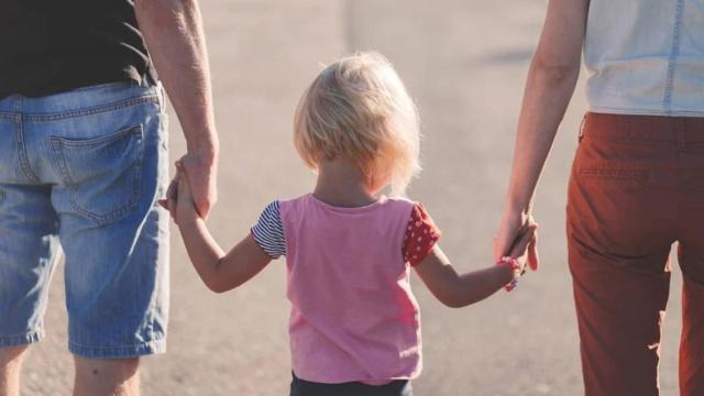Dos padres sujetan a su hija de la mano / PIXABAY