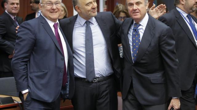 El Comisario de Finanzas, Pierre Moscovici, saluda al ministro español de Economía, Luis de Guindos, y a Michel Sapin (I), titular francés de la misma cartera / EFE