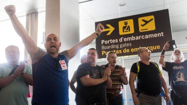 Los trabajadores de Eulen, con pegatinas de UGT y CCOO, protestan ante los arcos de seguridad de El Prat en una imagen de archivo / CG