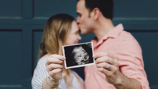 Padres mostrando una ecografía de su futuro hijo / UNSPLASH
