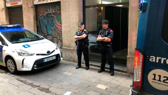 Una imagen de archivo de agente de la Guardia Urbana y uno de los Mossos d'Esquadra custodiando dos narcopisos vaciados en Barcelona / CG