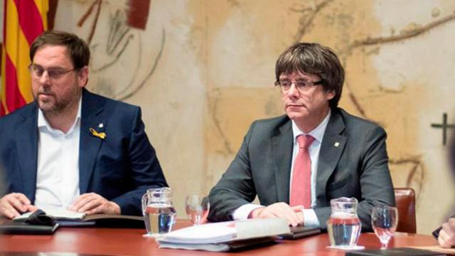 El presidente de la Generalitat, Carles Puigdemont (d), y el vicepresidente, Oriol Junqueras (i), durante la reunión semanal del gobierno catalán / EFE