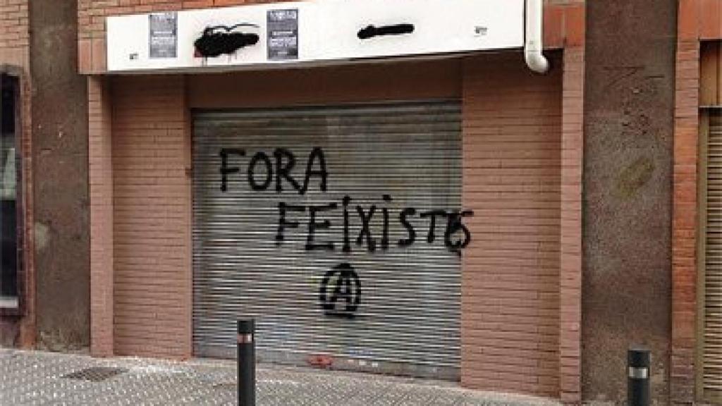 Sede del PP de Les Corts, con pintadas en la persiana y en el cartel
