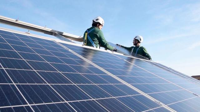 Dos operarios instalan placas solares en el tejado de un edificio / Cedida