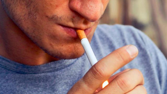 Un hombre encendiéndose un cigarillo