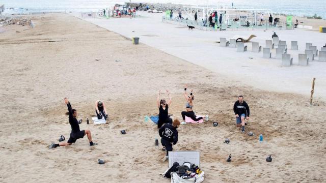 Varias personas haciendo ejercicio en la playa de Barcelona durante la pandemia de coronavirus / EFE
