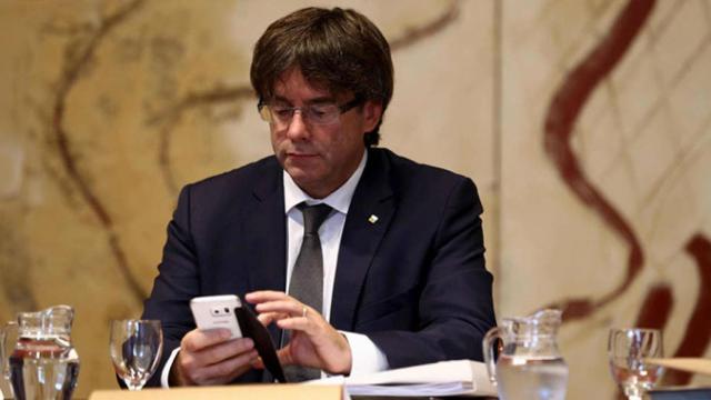 El presidente de la Generalitat, Carles Puigdemont, consulta su teléfono móvil / EFE