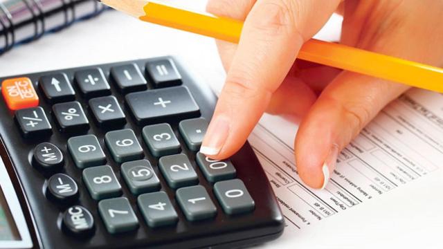 Una mujer haciendo cálculos de sus gastos e ingresos / CG