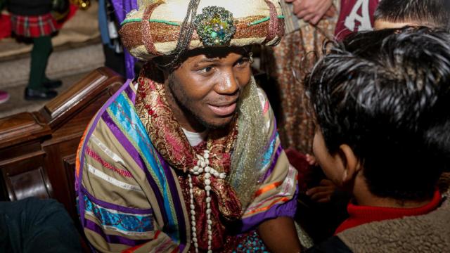 El Rey Mago Baltasar habla con un niño a su llegada a la Parroquia del Buen Suceso de Madrid / EP