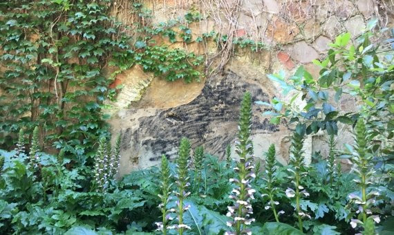 Puerta tapiada del antiguo Tren Fantasma en el muro del polvorín