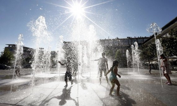 Unos niños se refrescan en las fuentes de Les Glòries / EFE