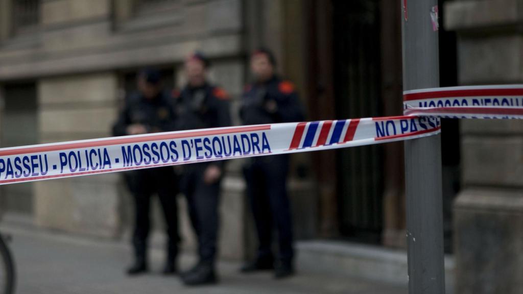 Agentes de los Mossos d'Esquadra custodian la sede de Òmnium, en la calle de la Diputació, durante el registro de la Guardia Civil / EFE QUIQUE GARCÍA