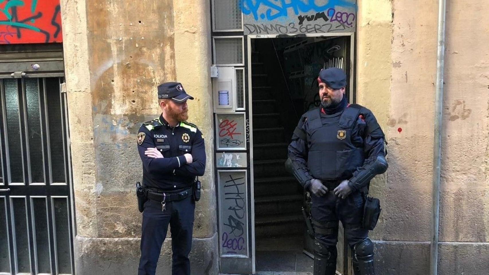 Dos agentes del cuerpo policial delante de una vivienda en Barcelona / EP